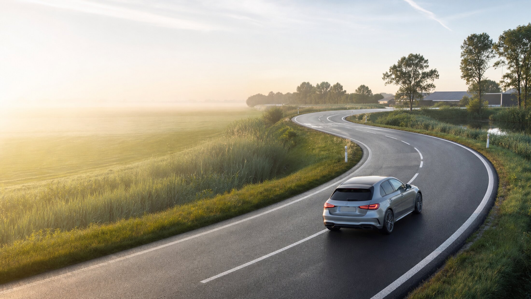 Auto op een landweg bij zonsopkomst